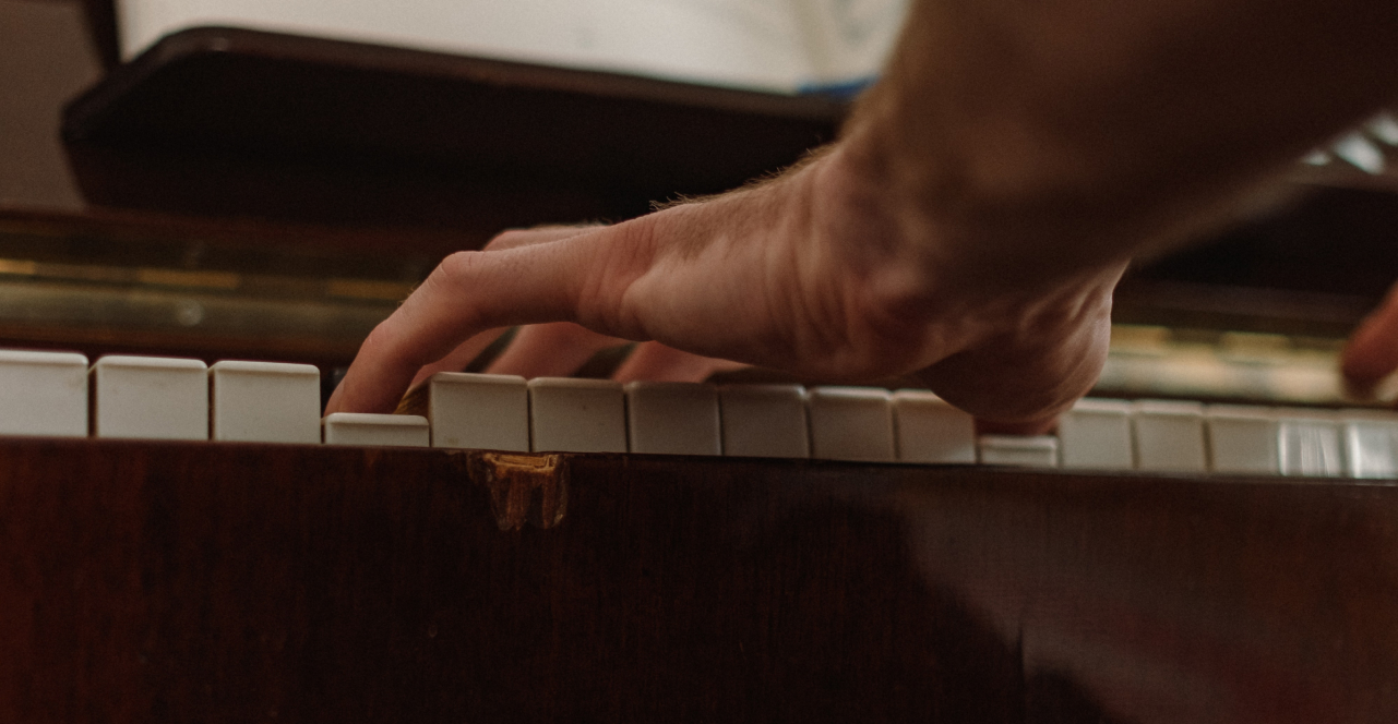 Hand playing a chord on a piano